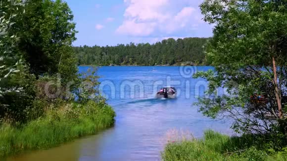 在明尼苏达州北部一个美丽的湖泊上船的华丽景象被森林包围视频的预览图