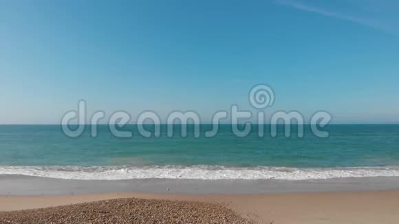 一个低空飞行的沙滩朝向水晶绿松石水的前进镜头在沙滩在沙滩下面撞击视频的预览图