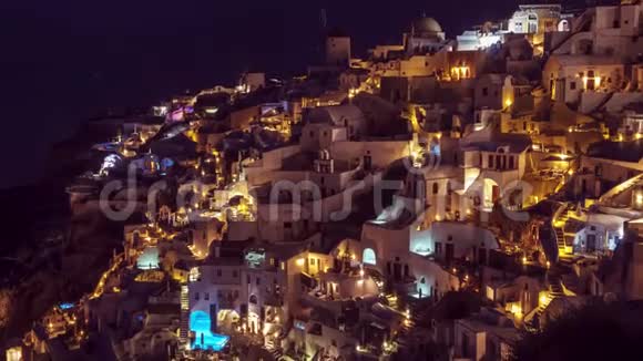 希腊圣托里尼的奥亚村夜晚人们蜂拥而至时间推移倾斜平移缩放视频的预览图