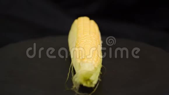 黑色背景下的成熟甜玉米豆荚的特写黑色背景下成熟玉米的特写视频的预览图
