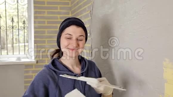 幸福的微笑女孩拿着铲子在公寓里修理视频的预览图