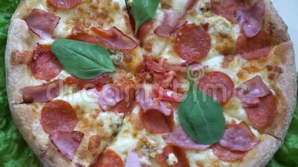 快关门带西红柿和奶酪背景的披萨在慢莫厨房餐桌上旋转视频的预览图