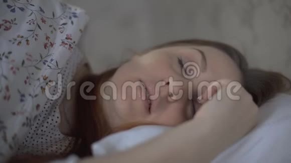 美丽的女人睡后睁开眼睛微笑视频的预览图