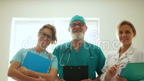 三名微笑医护人员男医生和两名穿着医疗服的护士医药和保健概念视频的预览图