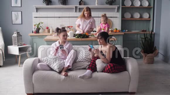 早晨家人坐在现代化厨房的正面景色视频的预览图