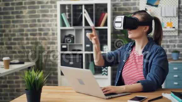 年轻女性在工作中使用虚拟现实眼镜休息时双手移动视频的预览图