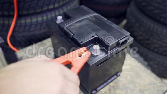 男性手连接终端到汽车的电池一个人抛出并移除电池上的终端视频的预览图