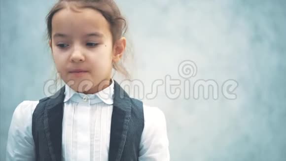一个灰色背景的小女孩的特写镜头在此期间手势类显示小企业老板视频的预览图