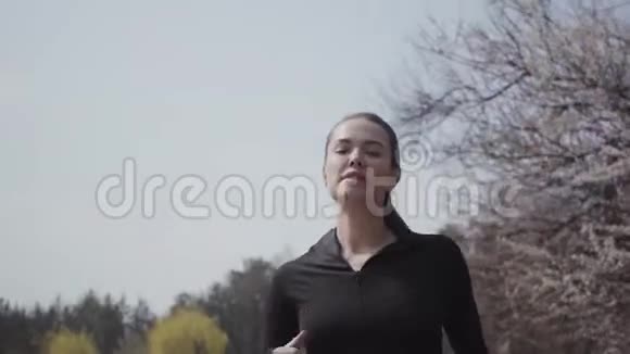 一位穿着运动服在河岸上奔跑的年轻女子的肖像积极的生活方式运动女主人把她视频的预览图