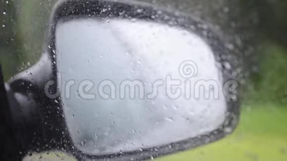 汽车侧镜和司机窗口的雨滴滑下它视频的预览图