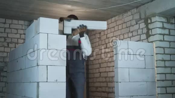 建筑工人用加气混凝土砌块建造门口视频的预览图