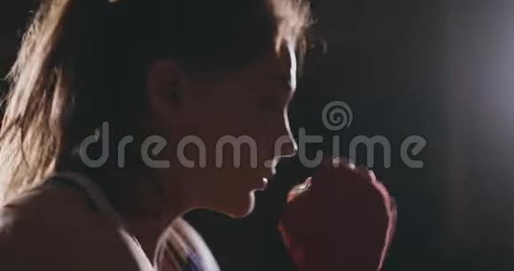 穿着红色绷带的拳击手女子和蓝t恤进行了练习速度和技巧的战斗视频的预览图