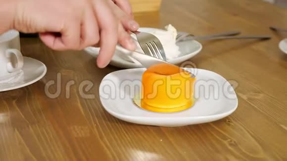1年轻人在餐桌上用白色盘子切苹果形状的蛋糕视频的预览图