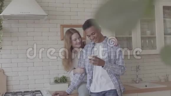 在厨房里一起休息的快乐国际家庭年轻的非裔美国人喝咖啡视频的预览图