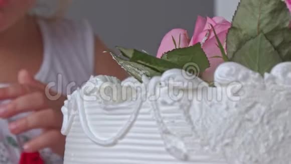 特写小女孩尝试用玫瑰装饰的结婚蛋糕视频的预览图