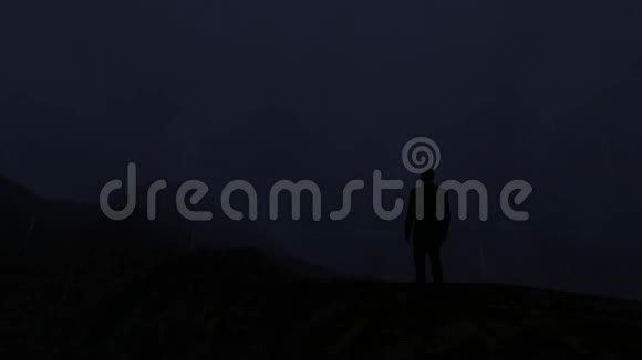 人类站在一座山上经历了严重的雷雨和闪电视频的预览图