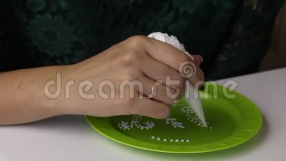 一个女人手里拿着一个带有白糖糖霜的糕点包来装饰姜饼检查釉料的质量视频的预览图