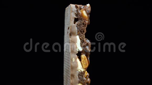 穆斯利被巧克力覆盖健康饮食巧克力棒旋转在黑色背景视频的预览图