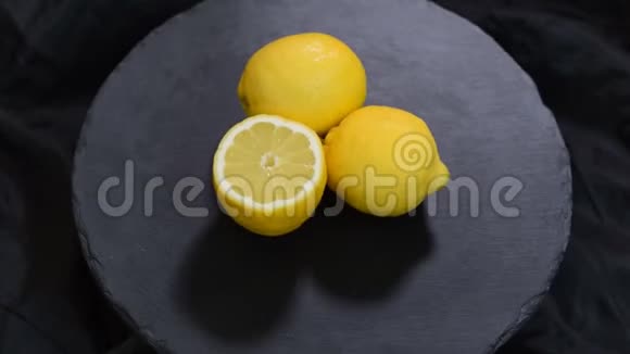 成熟的新鲜多汁的黄色柠檬在黑色背景旋转视频的预览图
