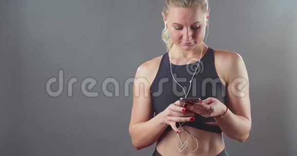 漂亮的运动女孩带着手机视频的预览图