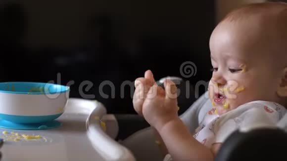 小可爱的宝贝看着他沾满食物的手高兴地拍手视频的预览图