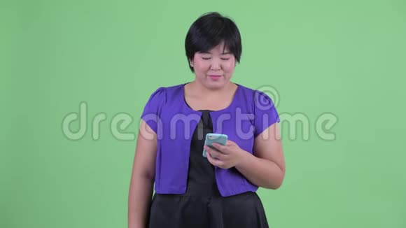 快乐的年轻超重的亚洲女人在等待电话视频的预览图