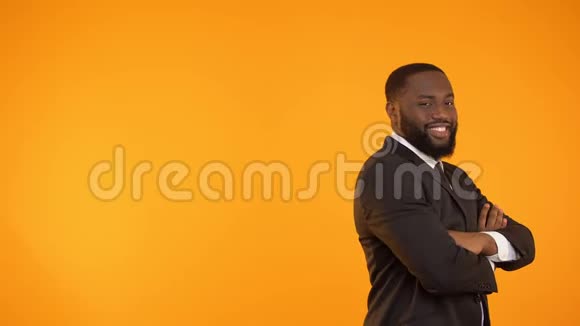穿着正式服装跳舞的搞笑黑人在橙色背景下被隔离视频的预览图