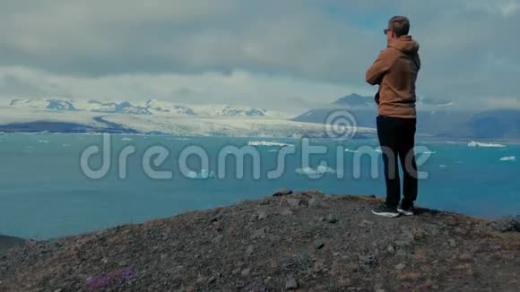 站在山顶人冰川泻湖视频的预览图
