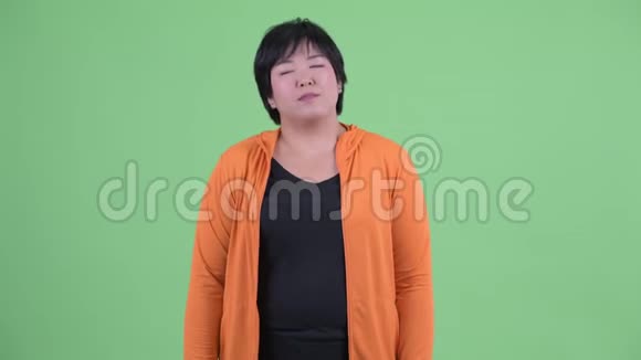 快乐的年轻超重的亚洲女人闭着眼睛放松视频的预览图