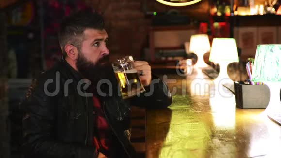 有胡子的野蛮人在酒吧柜台喝啤酒英俊的男迷在酒吧看体育比赛视频的预览图