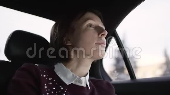 漂亮的女人棕色头发穿着白色衬衫和栗色毛衣坐在车里解释去她家的正确方式视频的预览图