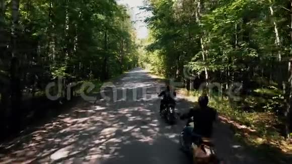 两个野蛮的人骑摩托车在森林里阳光明媚的一天视频的预览图