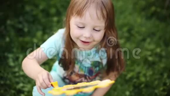 超级可爱的金发小女孩穿着t恤在草地上吹肥皂泡视频的预览图