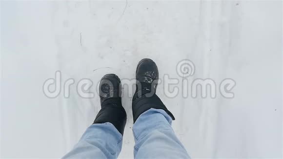 一个穿着黑色靴子的人在白雪中行走腿的特写慢动作视频的预览图