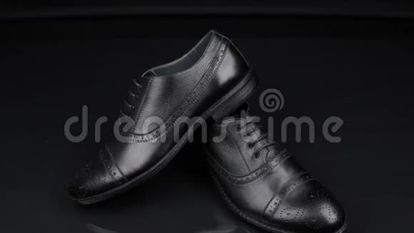 走近一双黑色经典男子鞋子站在黑色背景上男士时尚视频的预览图