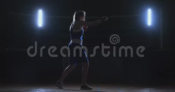 穿着红色绷带的拳击手女子和蓝t恤进行了练习速度和技巧的战斗视频的预览图