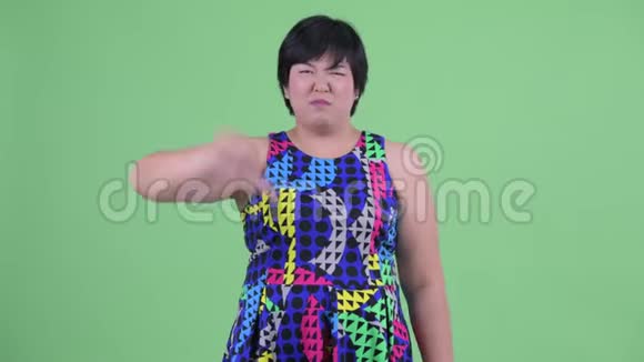 愤怒的年轻超重亚洲女人竖起大拇指视频的预览图