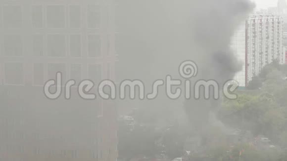 公用事业大楼着火了明火和烟羽上升到地面和周围的建筑物视频的预览图