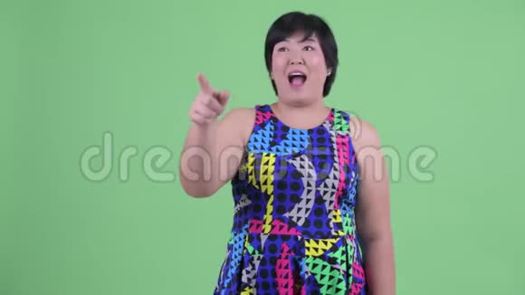 快乐年轻超重的亚洲女人指指点点准备聚会视频的预览图