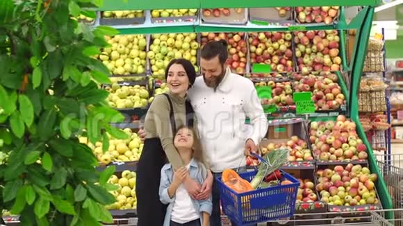 一个家庭在超市的肖像背景是货架上有苹果视频的预览图