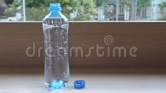 塑料瓶中的纯矿泉水气泡上升窗户附近的桌子上放着瓶装水视频的预览图