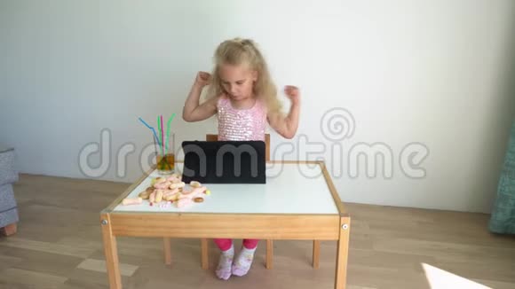 快乐的女孩坐在平板电脑旁表现出积极的情绪万向节运动视频的预览图