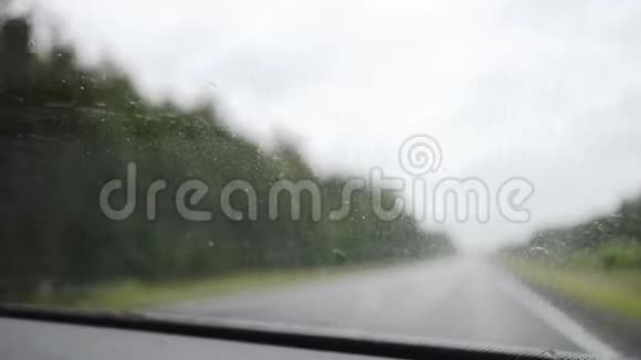 在雨中驾驶车内视野雨滴在汽车挡风玻璃上视频的预览图