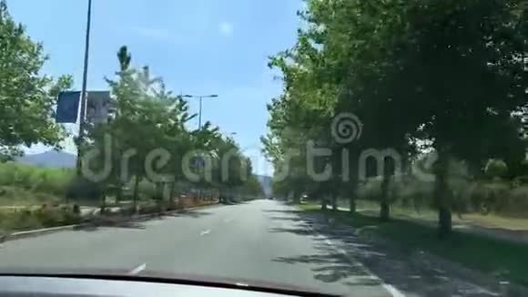 视频拍摄的同时驱车穿过城市道路和美丽的树木小巷视频的预览图
