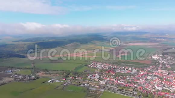 斯皮斯基城堡附近的村庄或小镇上的空中无人机景观斯洛伐克视频的预览图