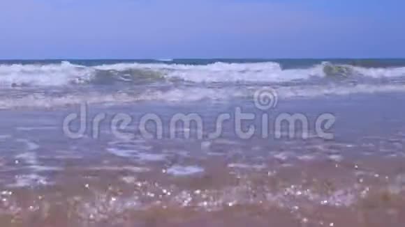 在阳光明媚的一天在暴风雨的大海中卷曲的长泡沫在管浪中滚动视频的预览图