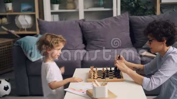 小男孩和妈妈一起玩完棋庆祝和击掌后很开心视频的预览图