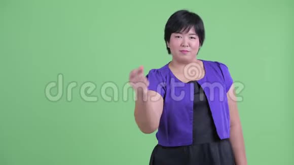快乐的年轻超重的亚洲女人拍手指展示一些东西视频的预览图
