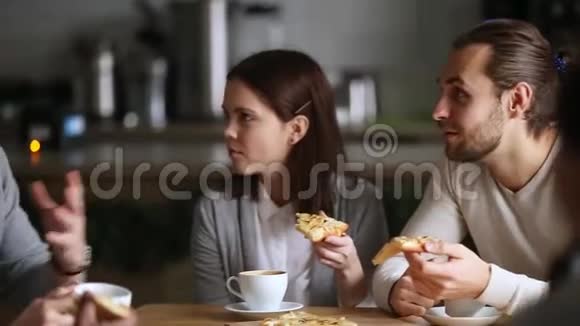 不同的同事休息吃比萨饼喝咖啡享受谈话视频的预览图