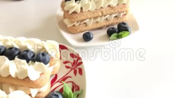 由萨沃亚迪饼干和奶油制成的蛋糕用蓝莓和薄荷装饰躺在盘子上视频的预览图
